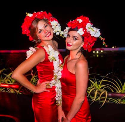 Two beautiful ladies wearing red dresses and floral hats at The Kingsbury Hotel