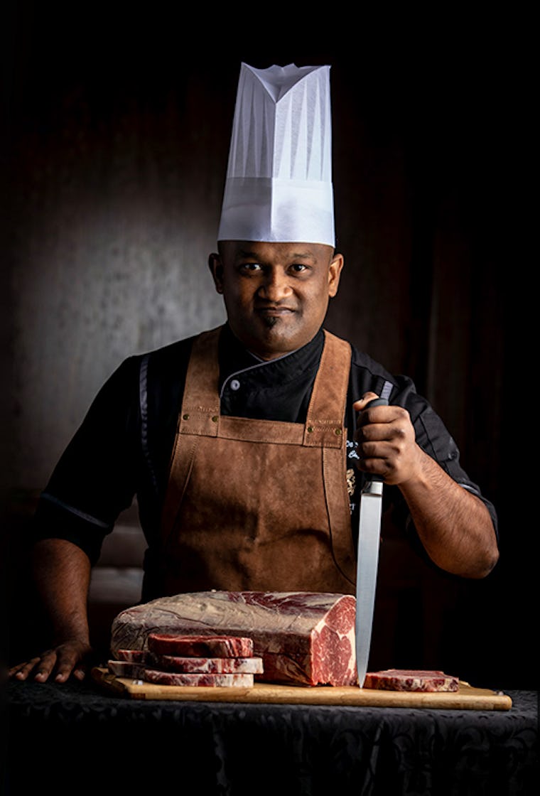 Chef posing with half cut steak at The Kingsbury Hotel