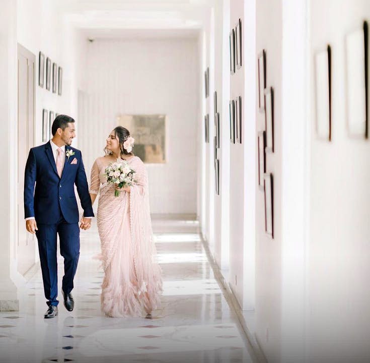 Married couple walking down a white hallway at The Kingsbury Hotel